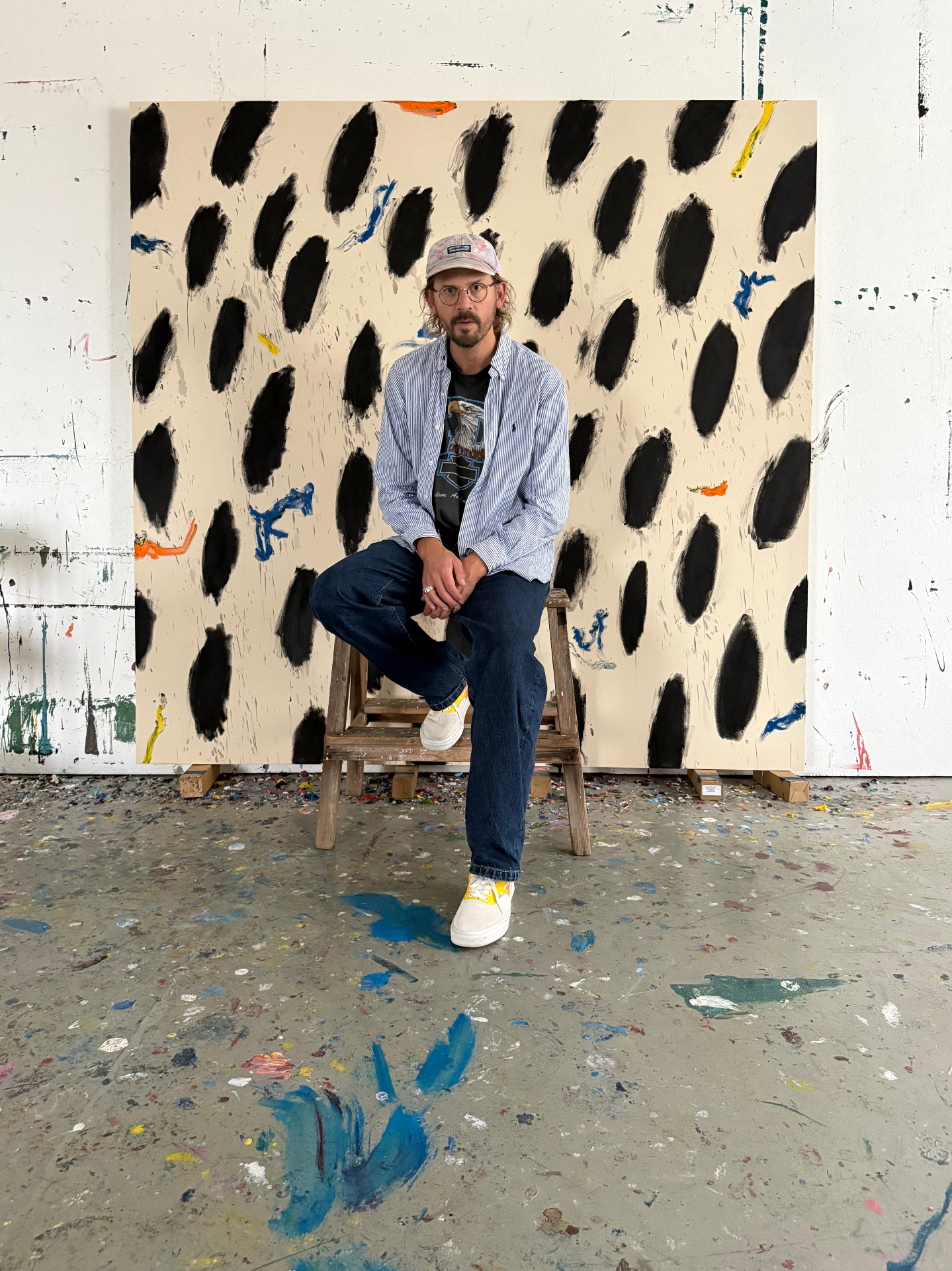 Gustav Hjelmgren seated in front of a large Dalmatin painting in his studio